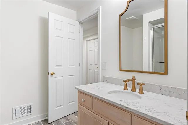 a bathroom with a granite countertop sink and a mirror