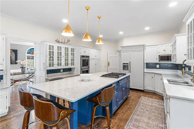 a kitchen with stainless steel appliances granite countertop a kitchen island a stove a table and chairs