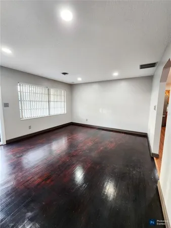 a view of empty room with wooden floor