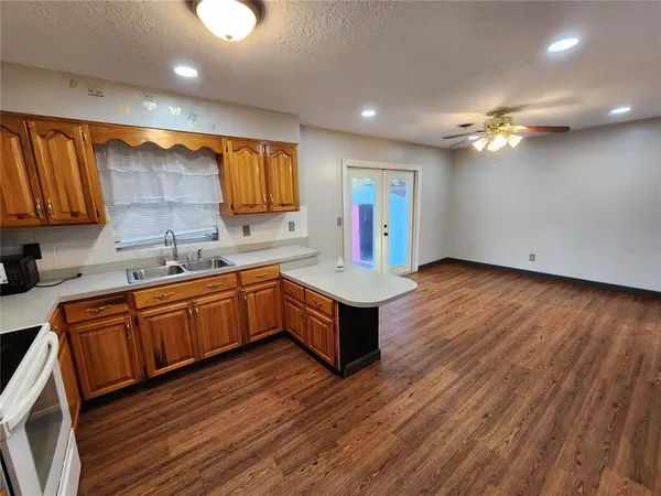 a kitchen with stainless steel appliances granite countertop a sink dishwasher stove and refrigerator with wooden floor