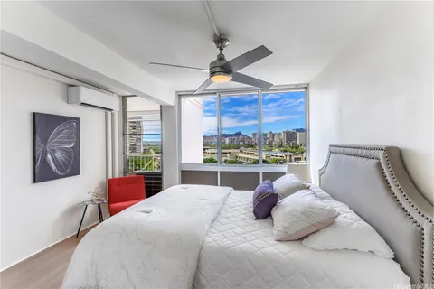 a bedroom with a bed ceiling fan and window