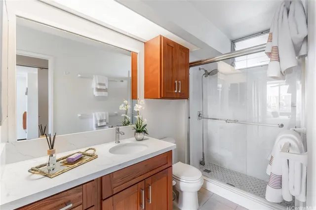 a bathroom with a granite countertop sink toilet and shower