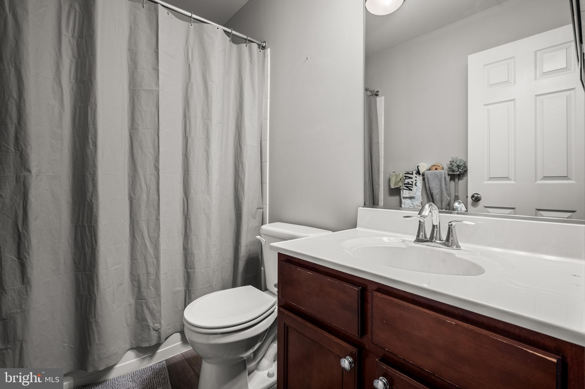 8020 Wright Place Shady Side, MD 20764 - Photo 11 of 21 a bathroom with a sink a toilet and shower curtain