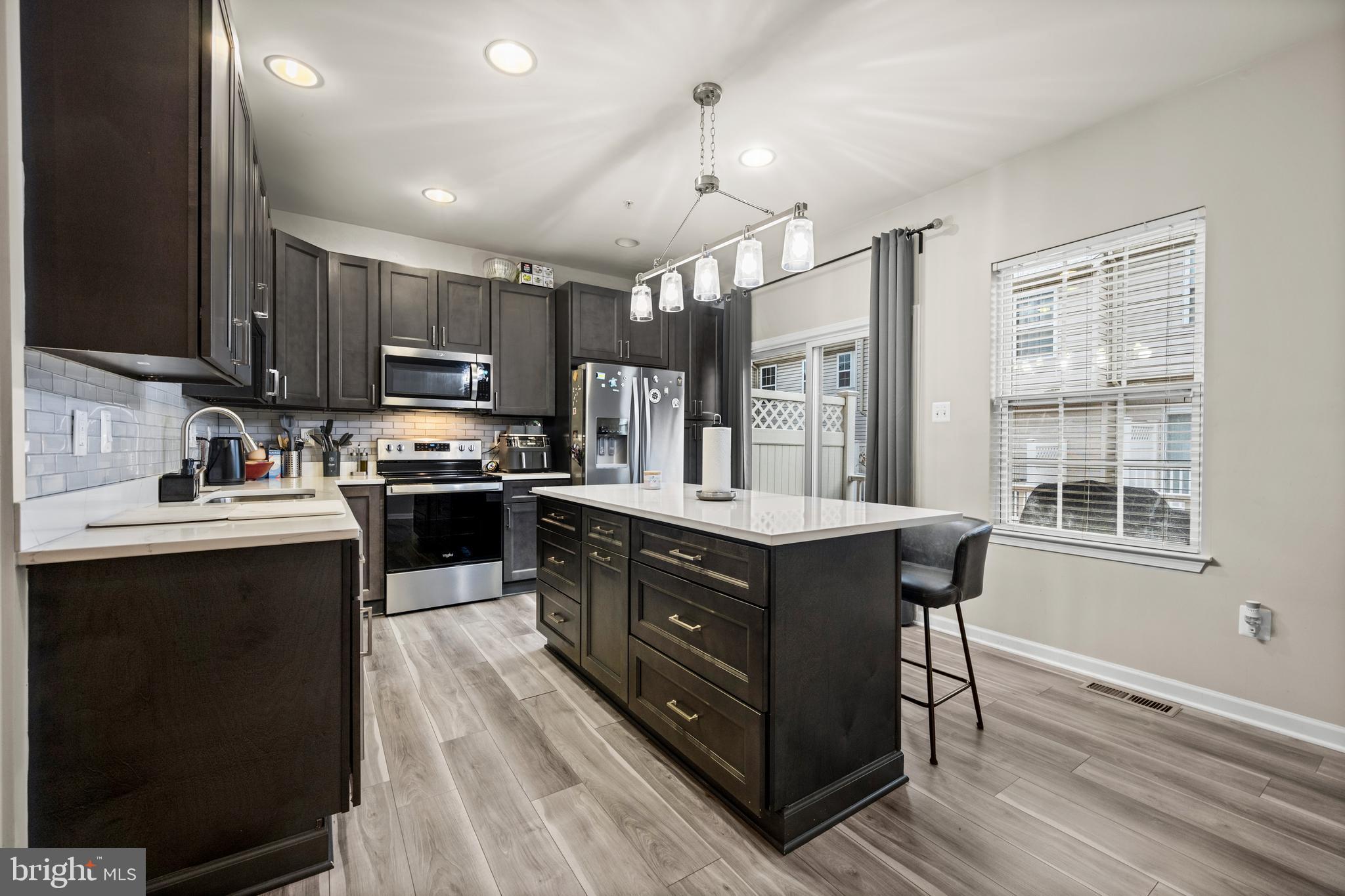 8020 Wright Place Shady Side, MD 20764 - Photo 6 of 21 a kitchen with kitchen island granite countertop a sink appliances and cabinets