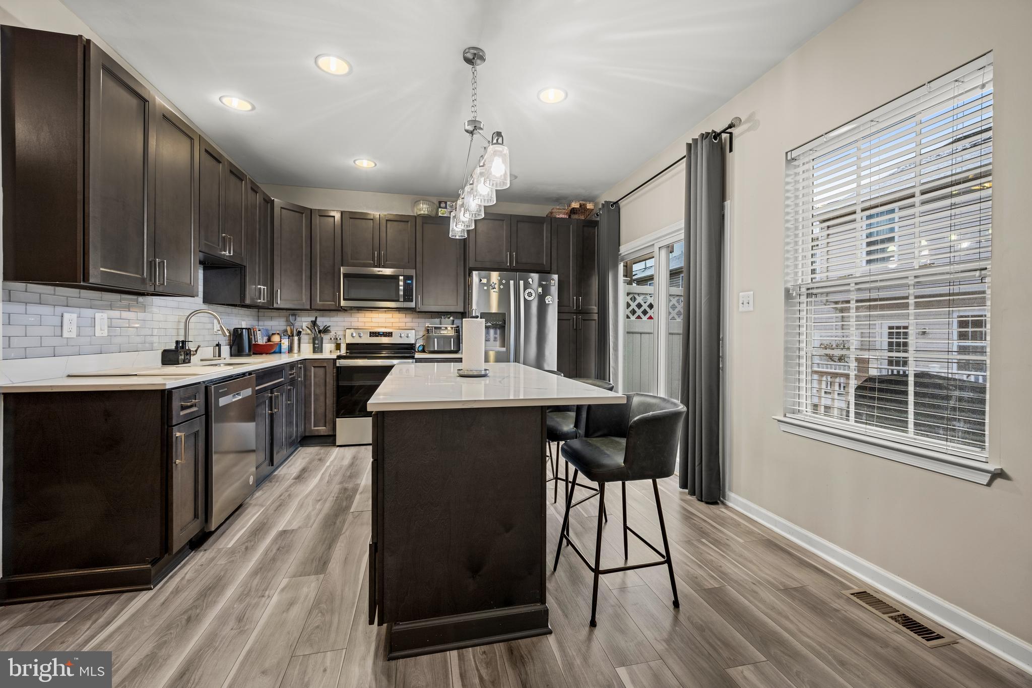 8020 Wright Place Shady Side, MD 20764 - Photo 7 of 21 a kitchen with kitchen island granite countertop wooden floors and stainless steel appliances