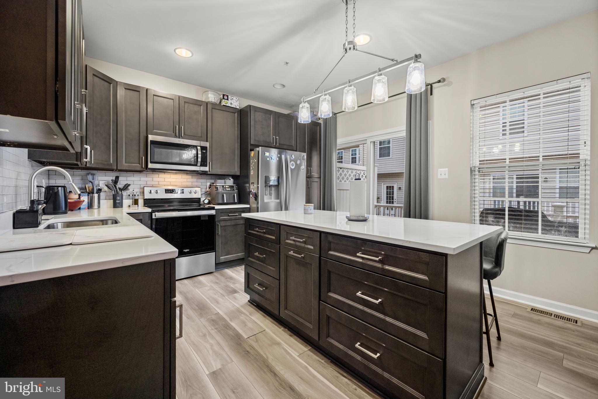 8020 Wright Place Shady Side, MD 20764 - Photo 9 of 21 a kitchen with a stove a sink and a refrigerator