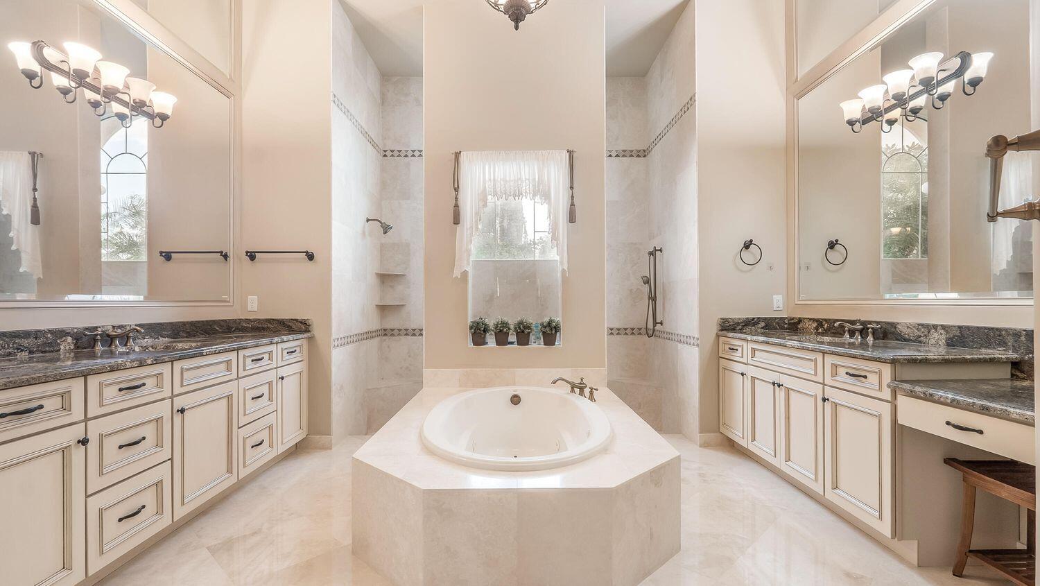 17384 Vistancia Circle Boca Raton, FL 33496 - Photo 14 of 27 a spacious bathroom with a granite countertop double vanity sink a mirror a bathtub and shower