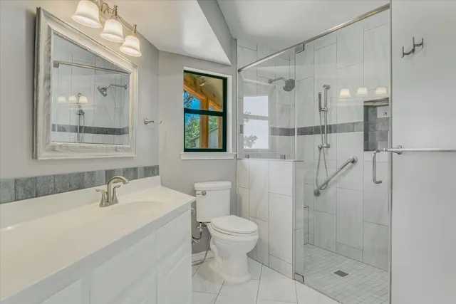 a bathroom with a shower sink mirror and toilet