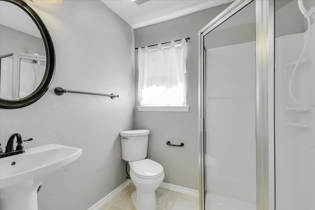 a bathroom with a toilet a sink and a mirror