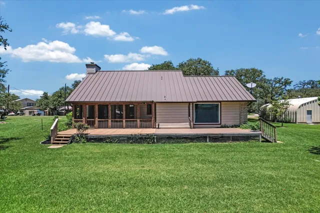a view of a house with a yard and sitting area