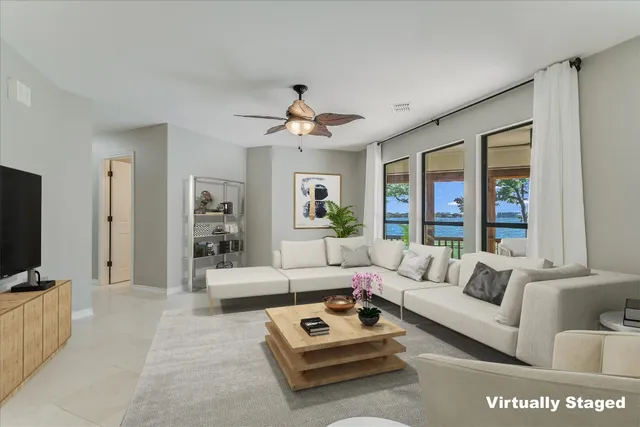 a living room with furniture a flat screen tv and a large window