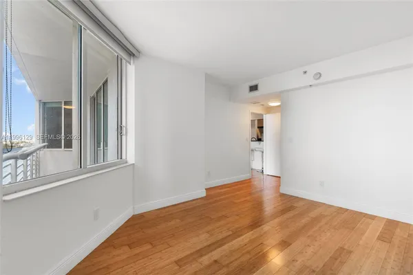 a view of a livingroom with wooden floor and a large window