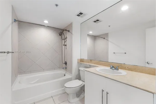 a bathroom with a sink a toilet a mirror a bathtub and shower