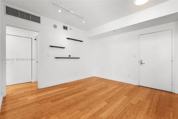 a view of empty room with wooden floor