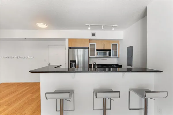 a kitchen with stainless steel appliances kitchen island a stove a sink and a refrigerator
