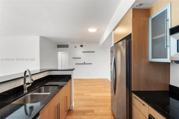 a kitchen with granite countertop a refrigerator and a sink