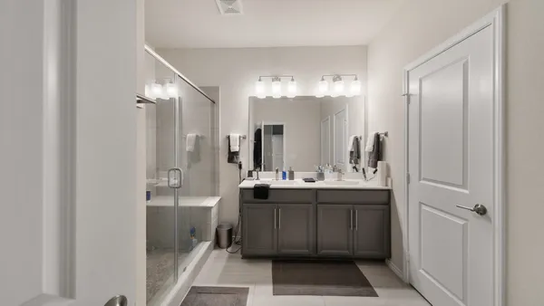 a bathroom with a double vanity sink mirror and shower