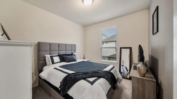 a bedroom with a bed a flat screen tv and window