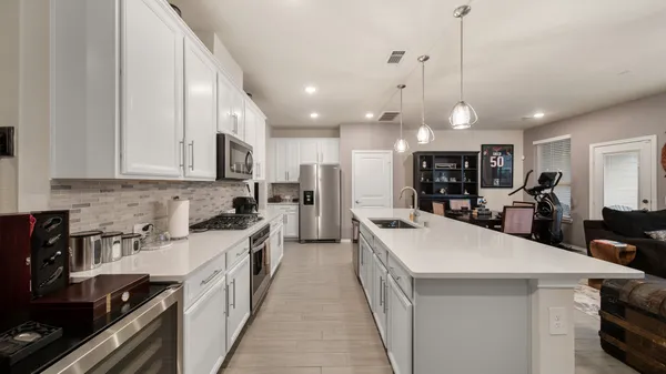 a kitchen with stainless steel appliances kitchen island a sink stove and cabinets