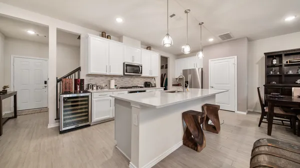 a kitchen with kitchen island white cabinets and stainless steel appliances