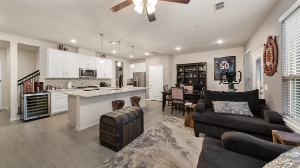 a living room with furniture and kitchen view
