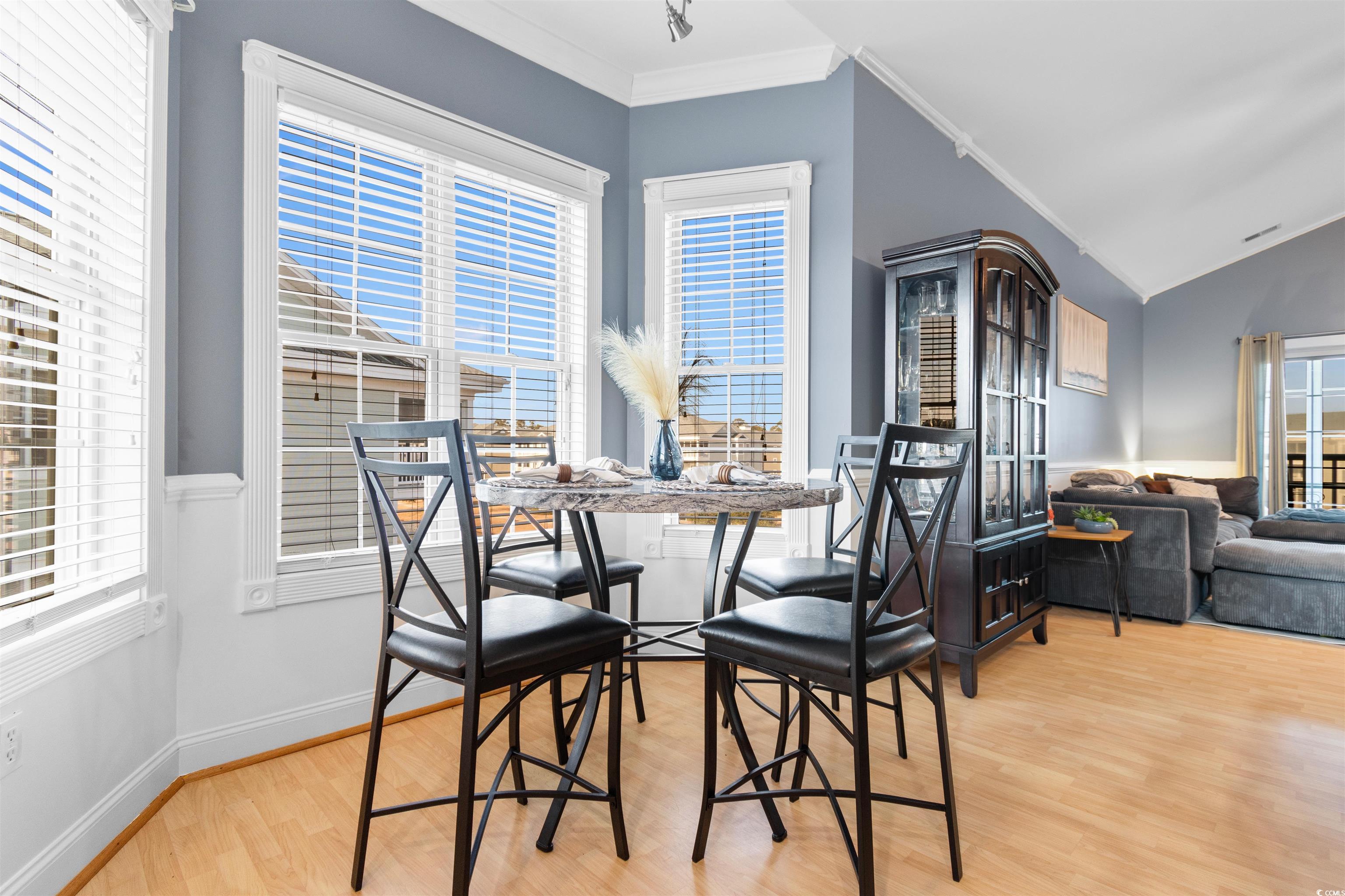 4891 Luster Leaf Circle, Unit 401 Myrtle Beach, SC 29577 - Photo 7 of 35 Dining area featuring light wood-style floors, healthy amount of natural light, crown molding, and vaulted ceiling