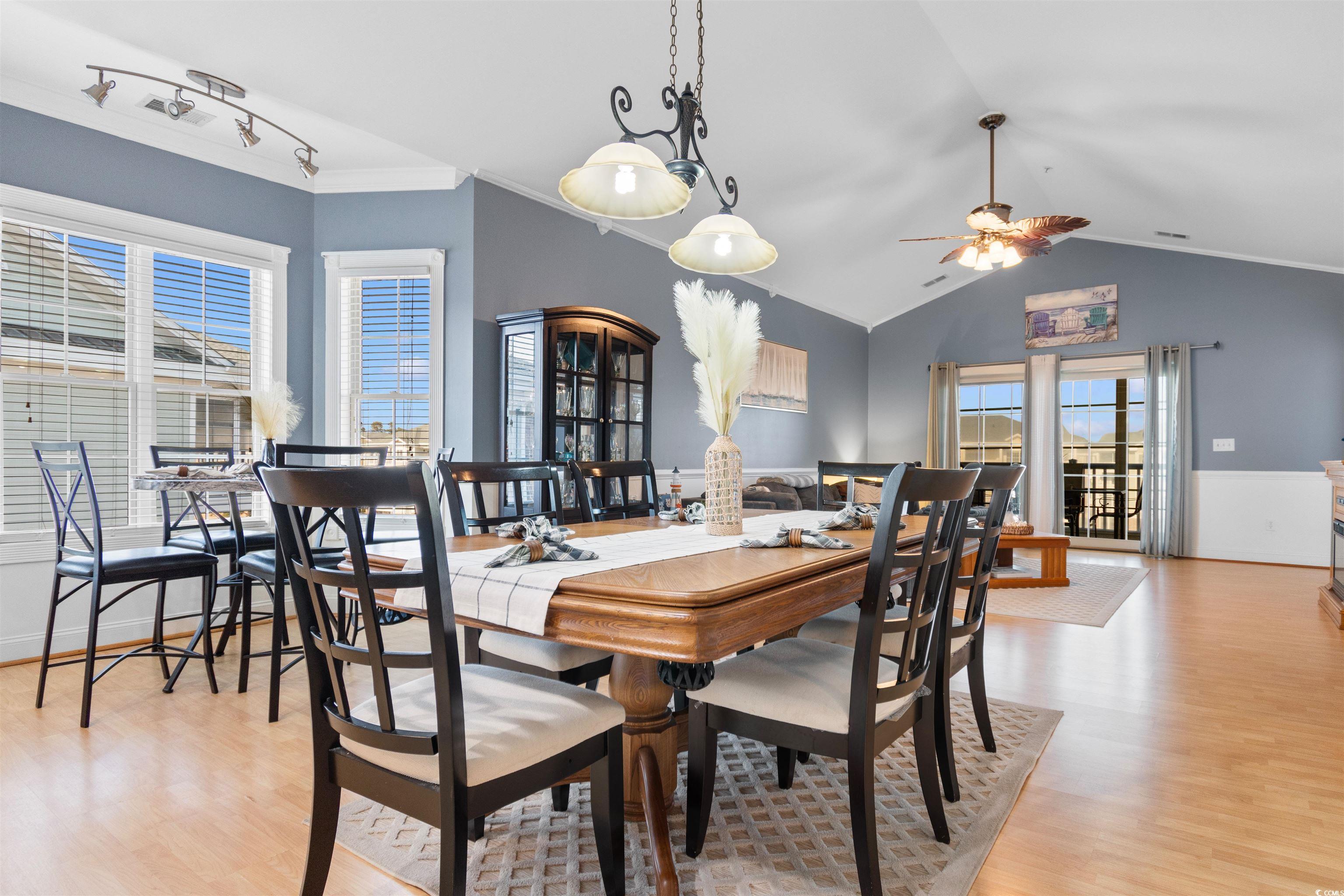 4891 Luster Leaf Circle, Unit 401 Myrtle Beach, SC 29577 - Photo 9 of 35 Dining room with crown molding, light wood-style flooring, vaulted ceiling, and ceiling fan
