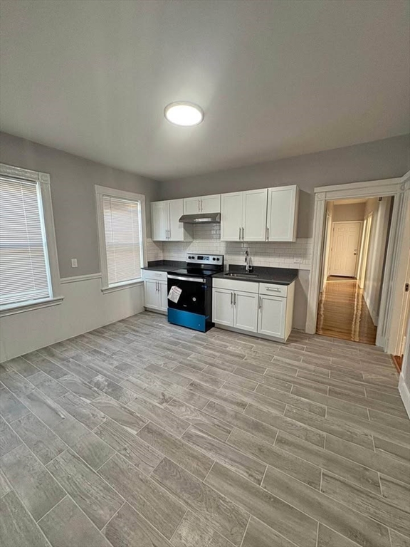 a large kitchen with kitchen island granite countertop a stove a sink and a granite counter tops