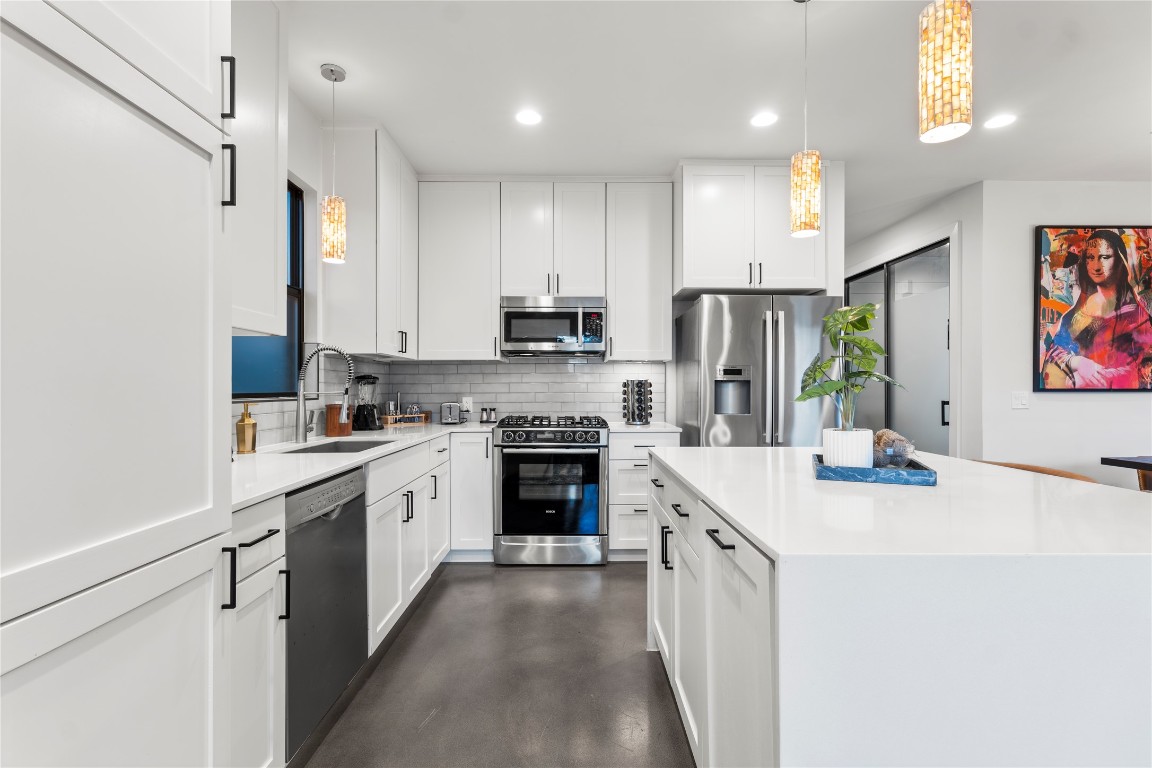 1105 East 12th Street Austin, TX 78702 - Photo 5 of 28 a kitchen with stainless steel appliances a stove sink refrigerator and cabinets