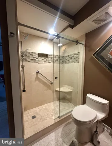 a bathroom with a granite countertop sink a toilet a mirror and bathtub