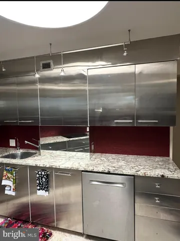 a kitchen with granite countertop a refrigerator and a sink