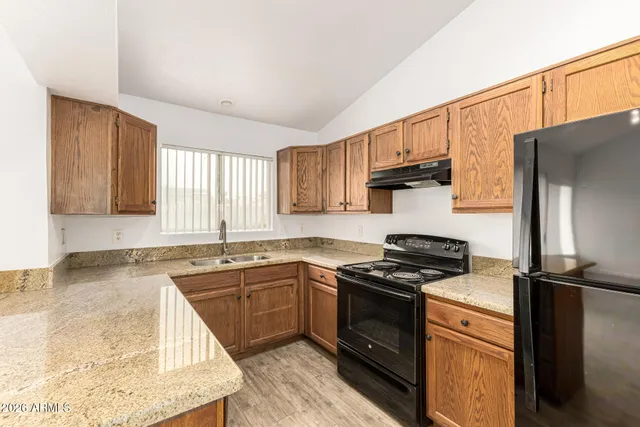 a kitchen with granite countertop a sink stainless steel appliances and cabinets