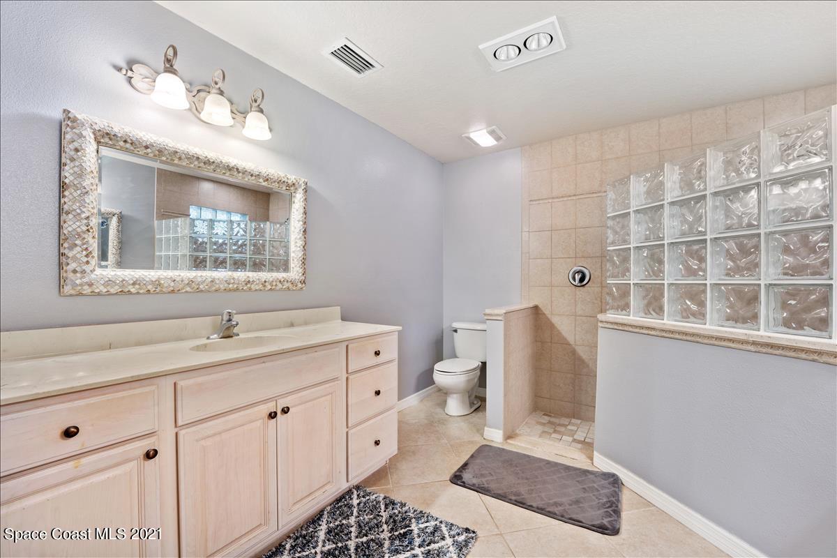2825 Corey Road Malabar, FL 32950 - Photo 14 of 44 a bathroom with a sink a toilet and a mirror