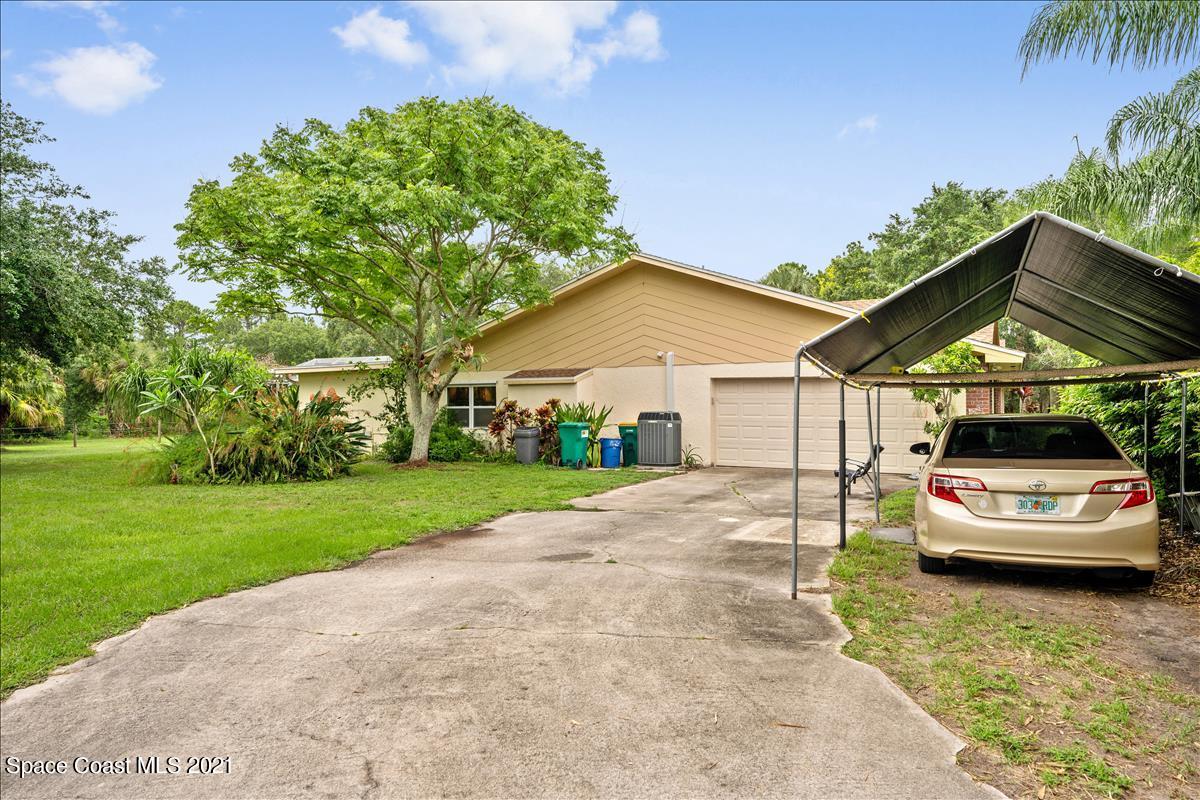 2825 Corey Road Malabar, FL 32950 - Photo 3 of 44 a car parked in front of a house with a yard