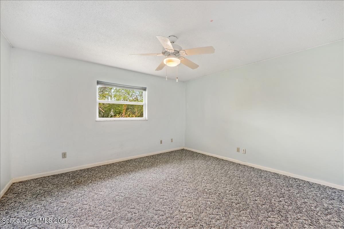 2825 Corey Road Malabar, FL 32950 - Photo 23 of 44 an empty room with a window and a ceiling fan