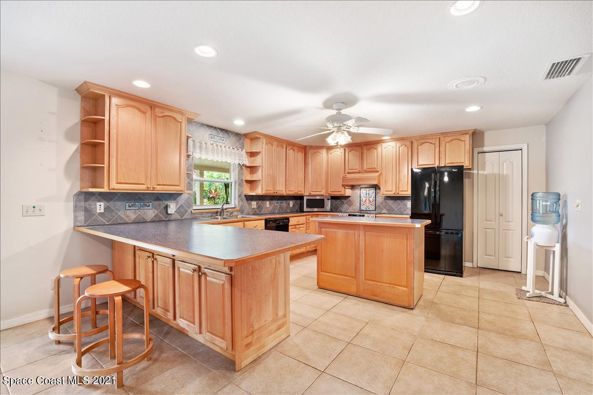 2825 Corey Road Malabar, FL 32950 - Photo 8 of 44 a kitchen with stainless steel appliances granite countertop a refrigerator and a sink