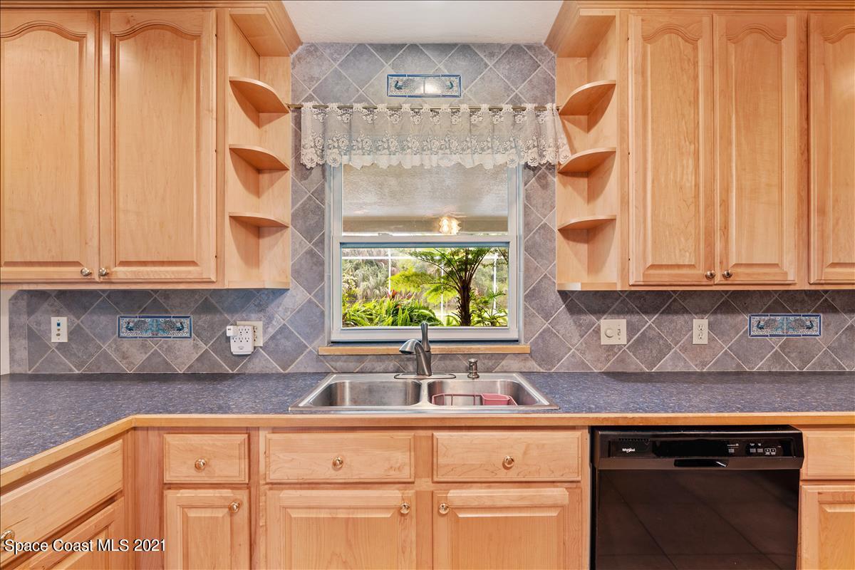 2825 Corey Road Malabar, FL 32950 - Photo 10 of 44 a kitchen with stainless steel appliances white cabinets and a window