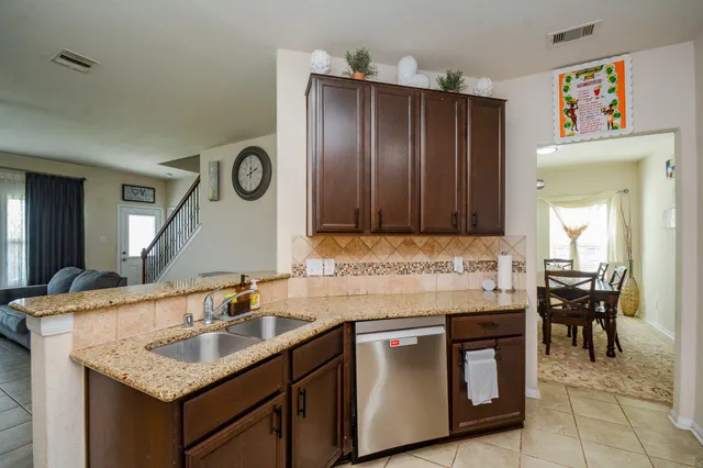 a living room with furniture and a view of kitchen