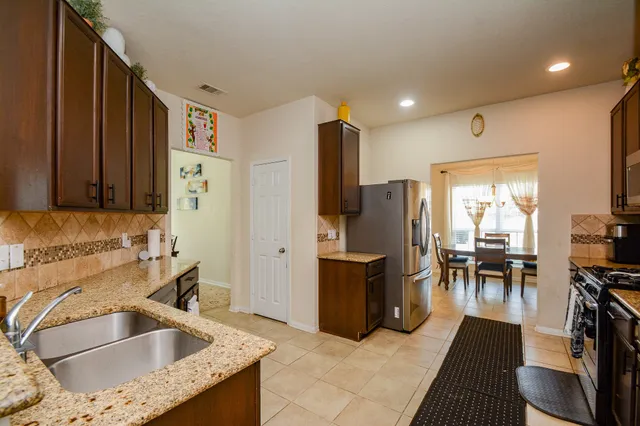 a kitchen with stainless steel appliances granite countertop a refrigerator and a table
