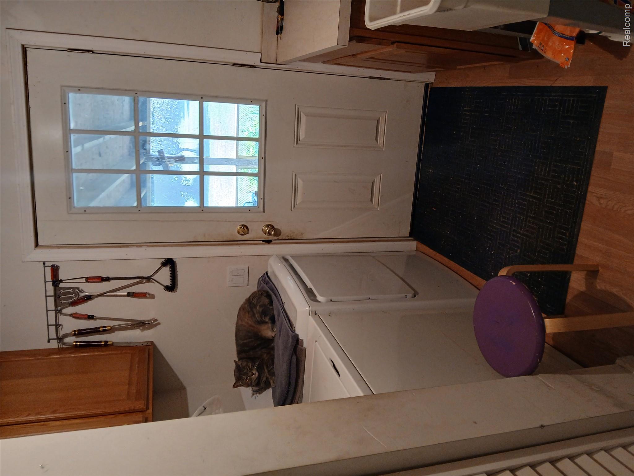 1938 North Englehart Road Deford, MI 48729 - Photo 20 of 27 Utility area featuring a wood-finish floor and white paneled door with a grid window