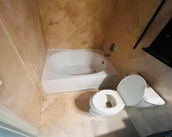 a bathroom with a toilet and a mirror