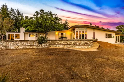 a view of a house with backyard and sitting area
