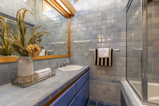 a view of a kitchen with kitchen island a stove a sink a dining table and chairs with wooden floor