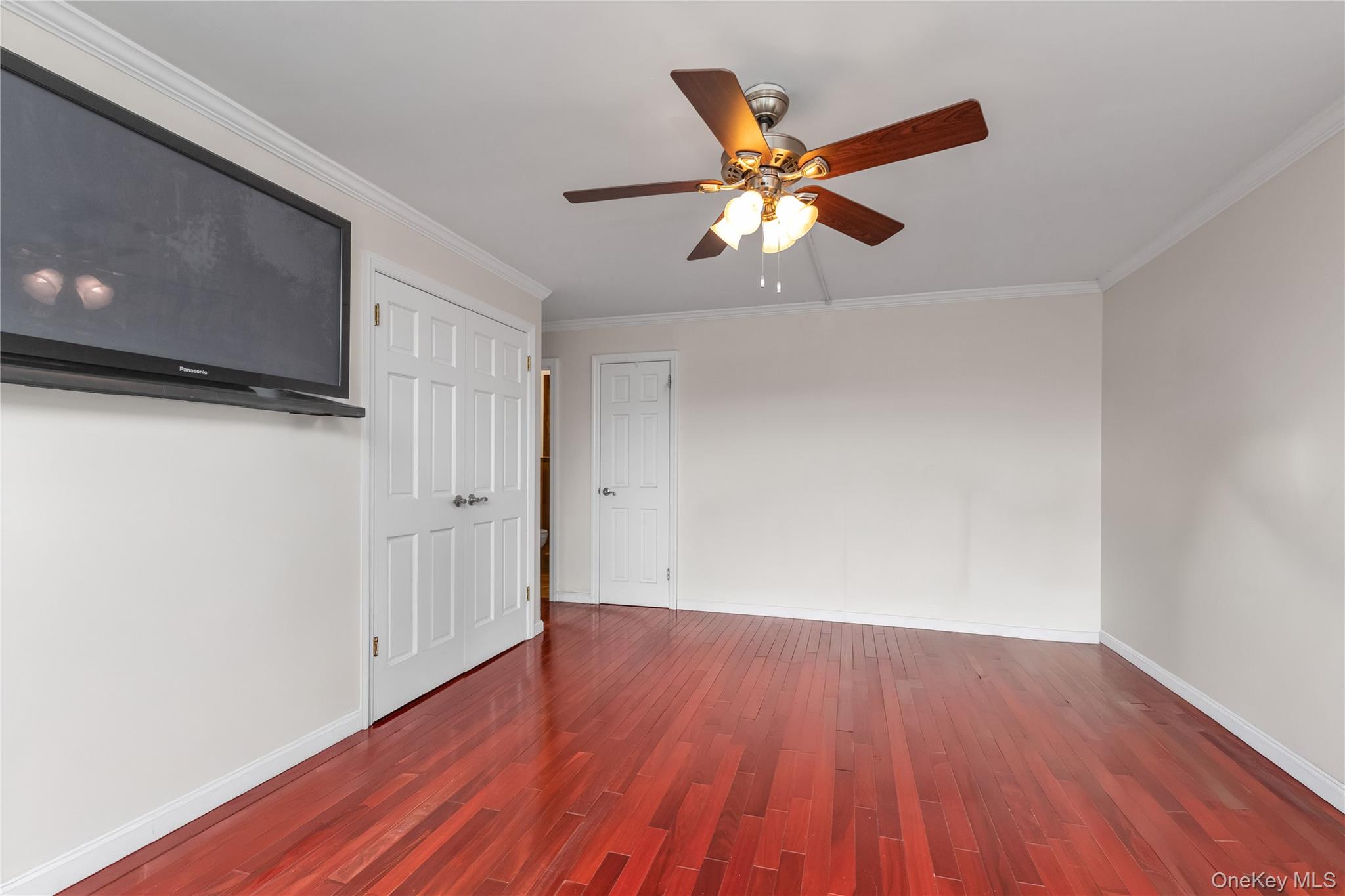 1 Bay Club Drive, Unit 4R Queens, NY 11360 - Photo 13 of 24 a view of a livingroom with wooden floor and a ceiling fan