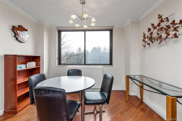 a kitchen with stainless steel appliances granite countertop a stove top oven a dining table and chairs with wooden floor