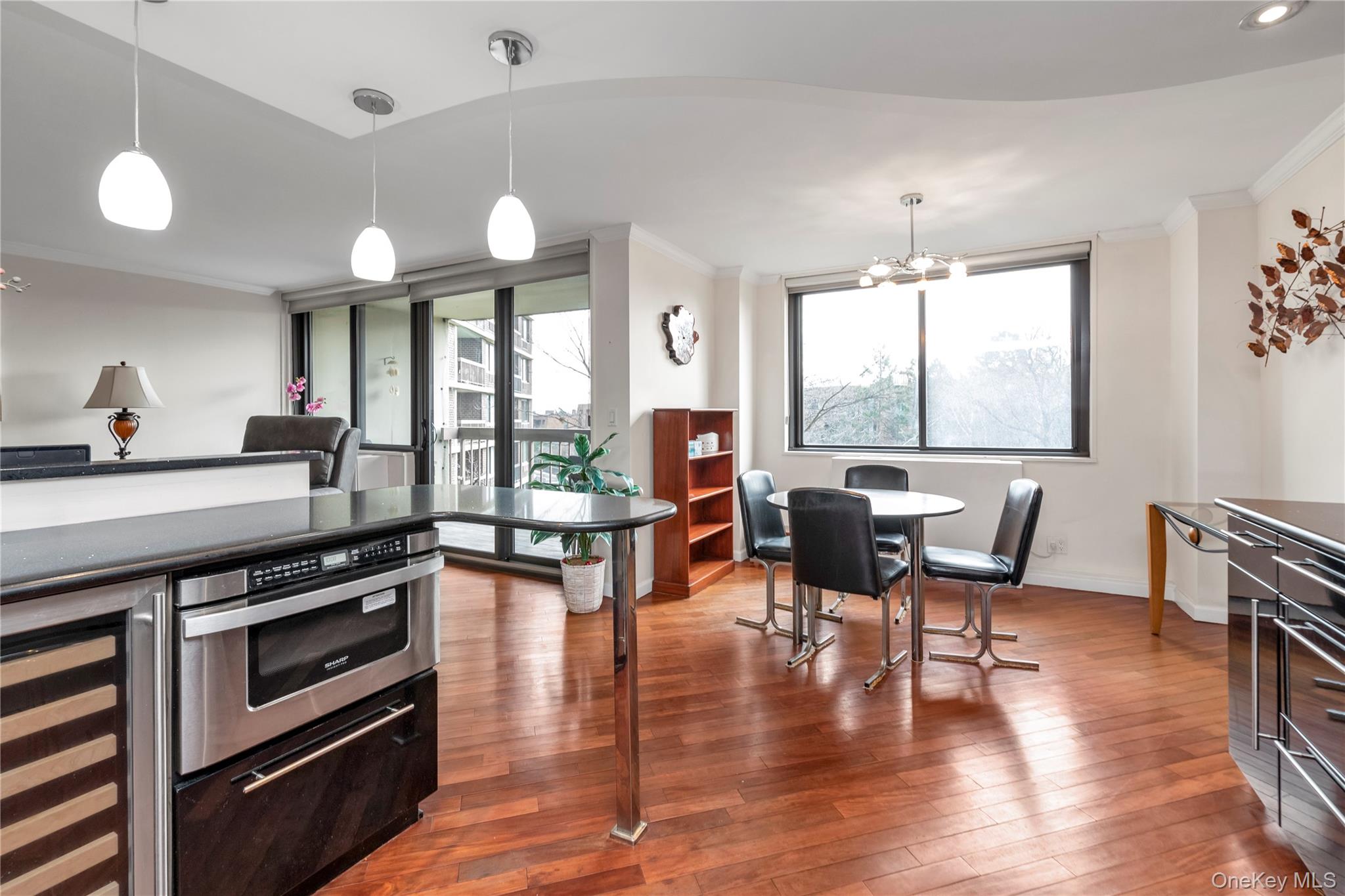 1 Bay Club Drive, Unit 4R Queens, NY 11360 - Photo 8 of 24 a kitchen with stainless steel appliances granite countertop a stove top oven a dining table and chairs with wooden floor