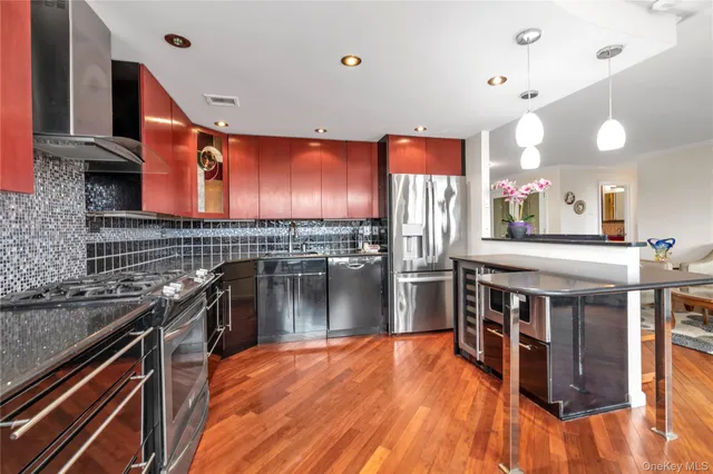 a kitchen with stainless steel appliances granite countertop a stove a sink and a microwave