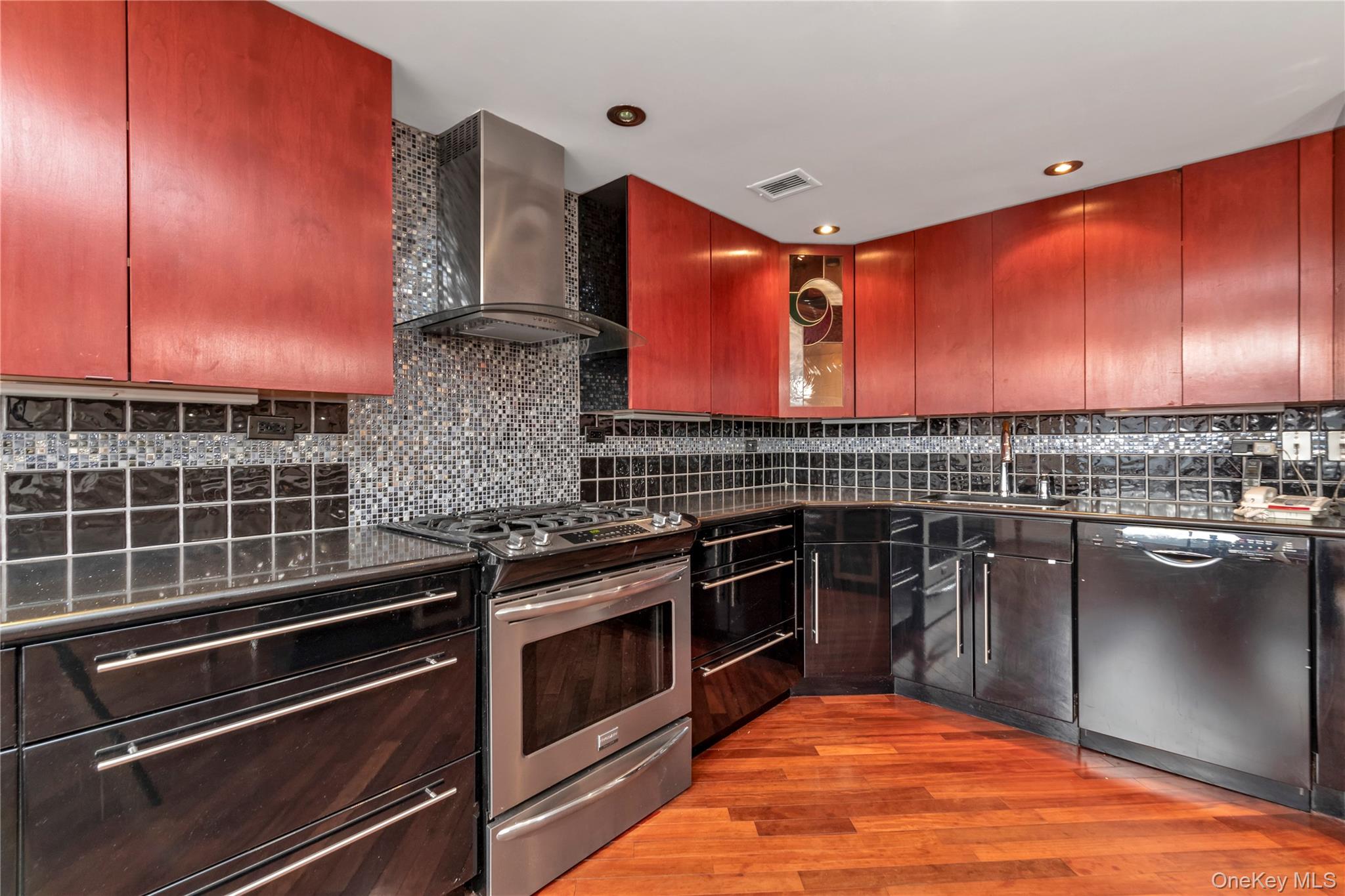 1 Bay Club Drive, Unit 4R Queens, NY 11360 - Photo 10 of 24 a kitchen with stainless steel appliances granite countertop a stove a sink and a microwave