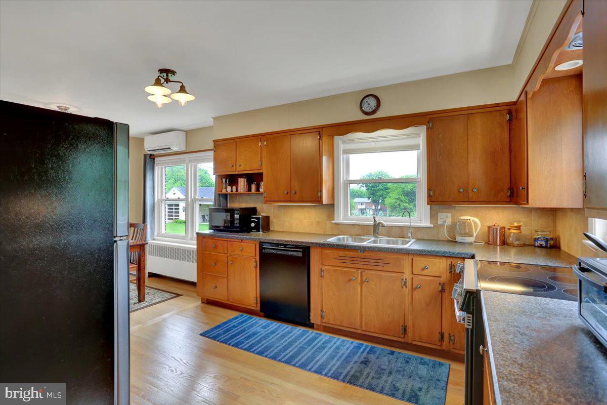 202 Old Fritztown Road Reading, PA 19607 - Photo 9 of 30 a kitchen with stainless steel appliances granite countertop a refrigerator a sink dishwasher a stove and a dining table with wooden floor