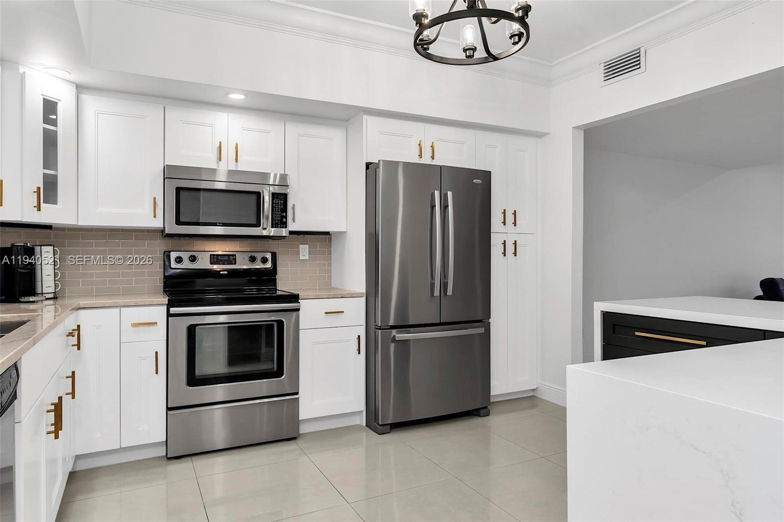 8898 Southwest 62nd Terrace, Unit 7F Miami, FL 33173 - Photo 15 of 66 a kitchen with stainless steel appliances a refrigerator sink and microwave